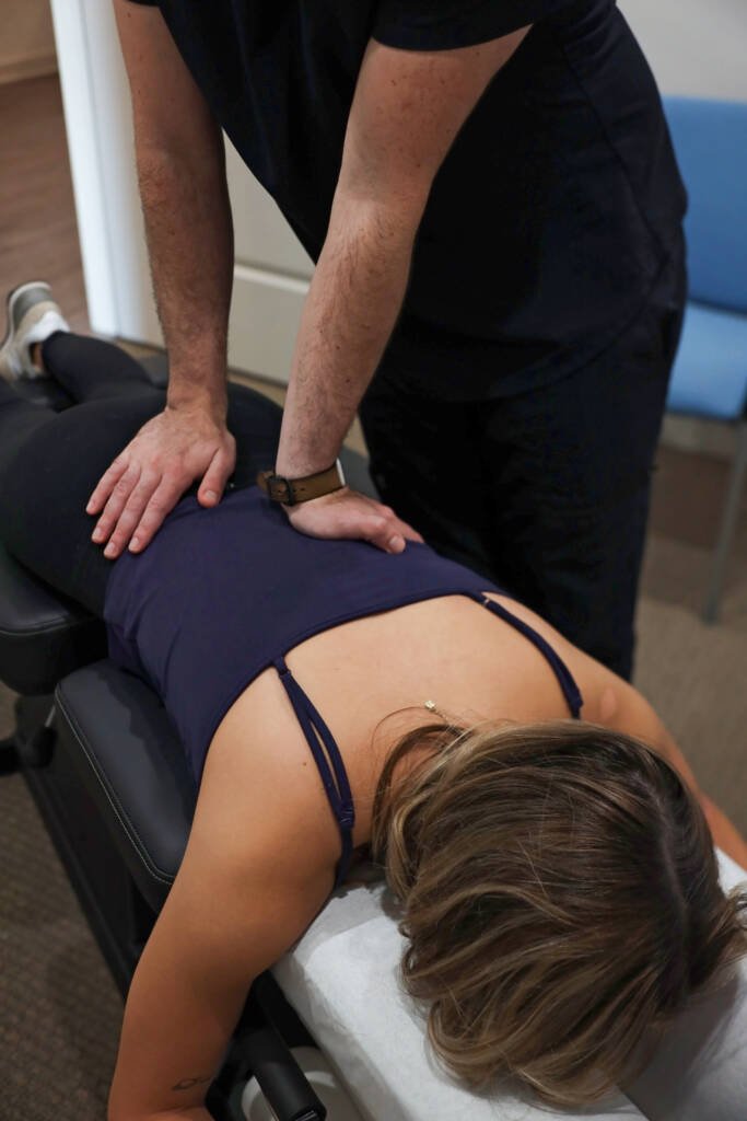 Chiropractor applying a gentle hands-on adjustment to a patient’s mid back during herniated disc care