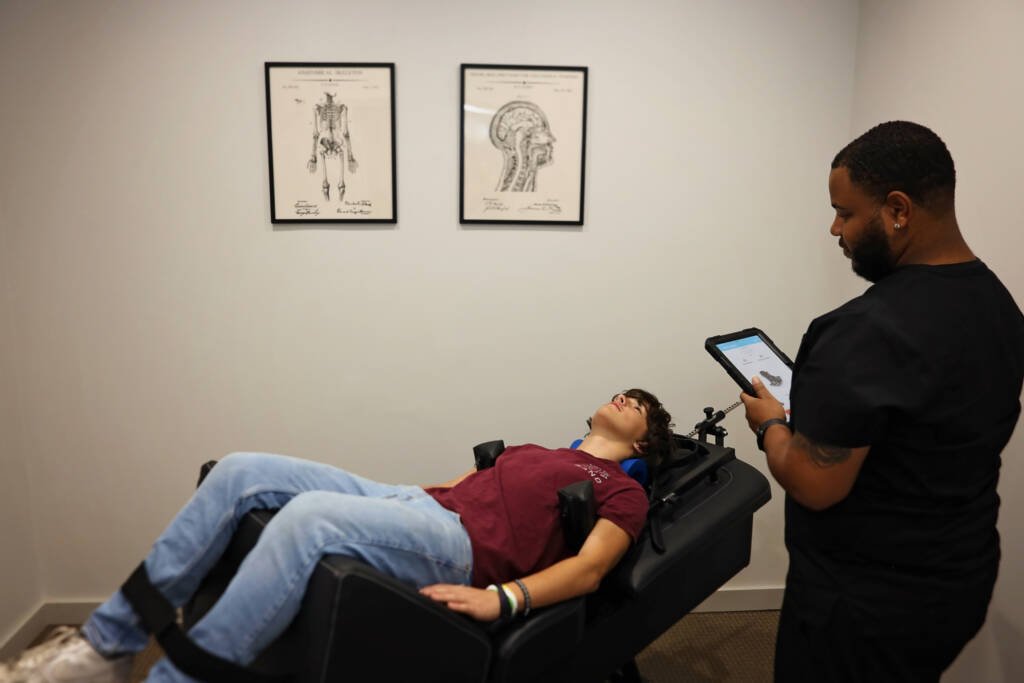 Patient receiving spinal decompression therapy on a decompression table at Urgent Chiropractic of Steele Creek