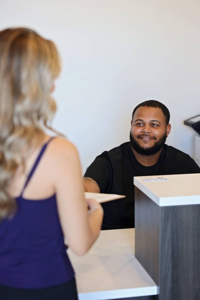 Front desk team member welcoming a patient at Urgent Chiropractic of Steele Creek in Charlotte, NC